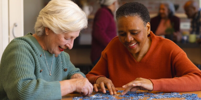 Two Elderly Women Doing a Puzzle Together at a Memory Care Facility