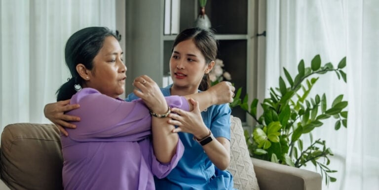 Female Nurse Helping Elderly Resident Stretch at Memory Care Facility